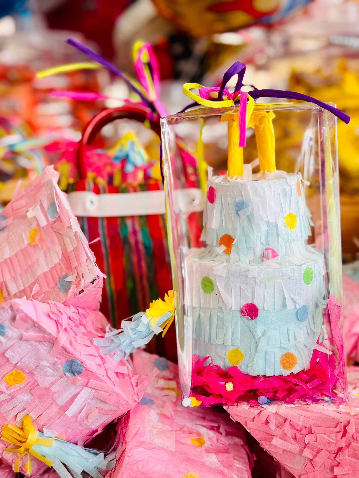 Photo of Piñata packs encased in clear packaging adorned with colorful ribbons